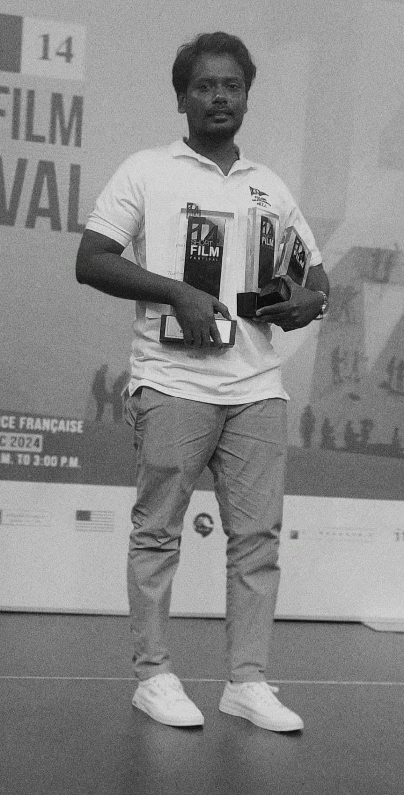 A member of the Crisis team on stage holding the three Agenda 14 Short Film Festival awards