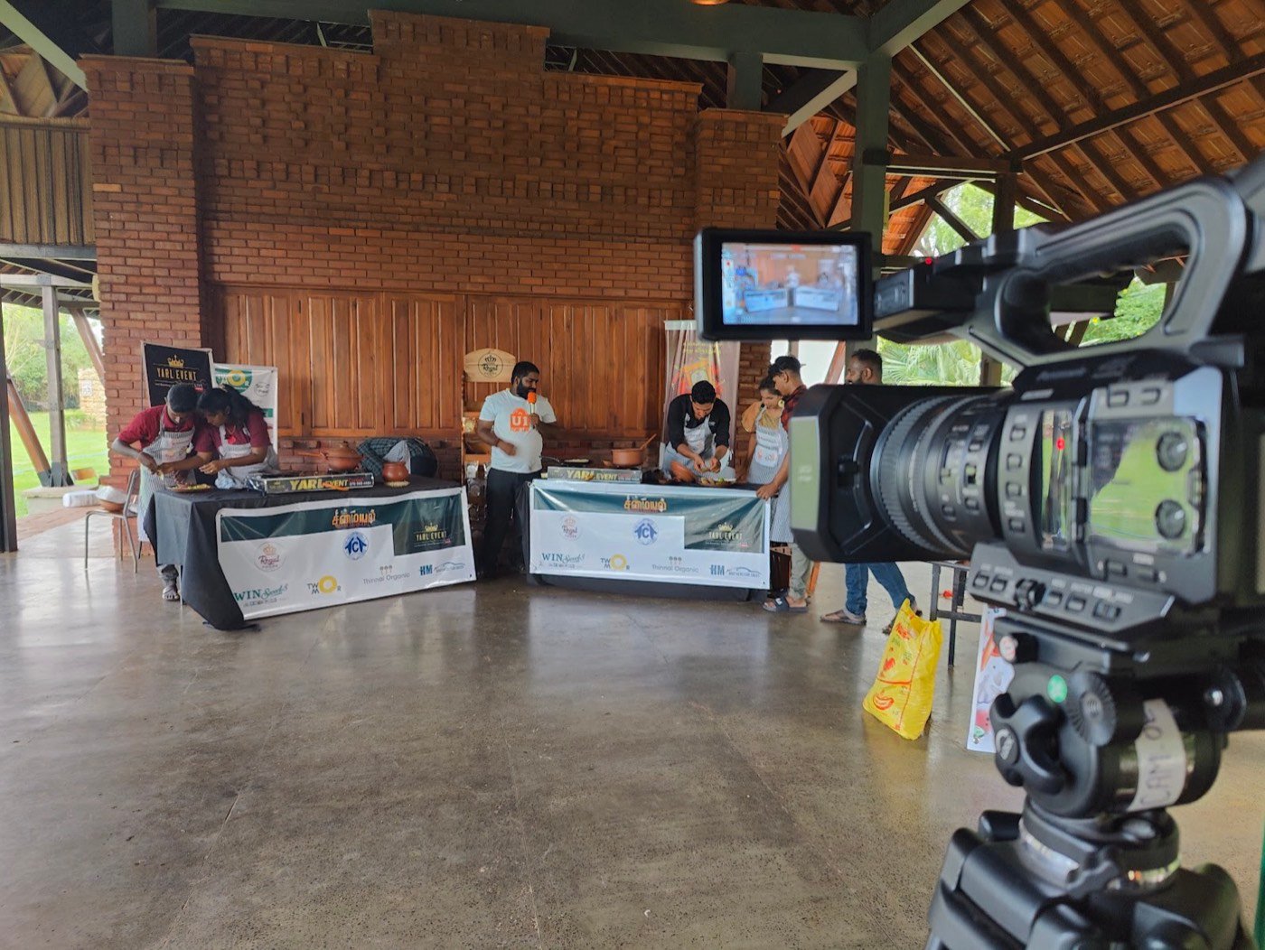 Camera recording a cooking competition inside a brick hall