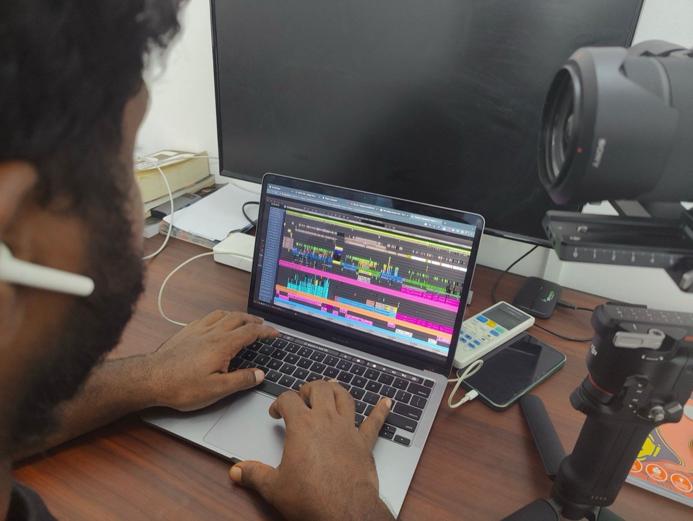 An editor working on a busy multi-track timeline on a laptop