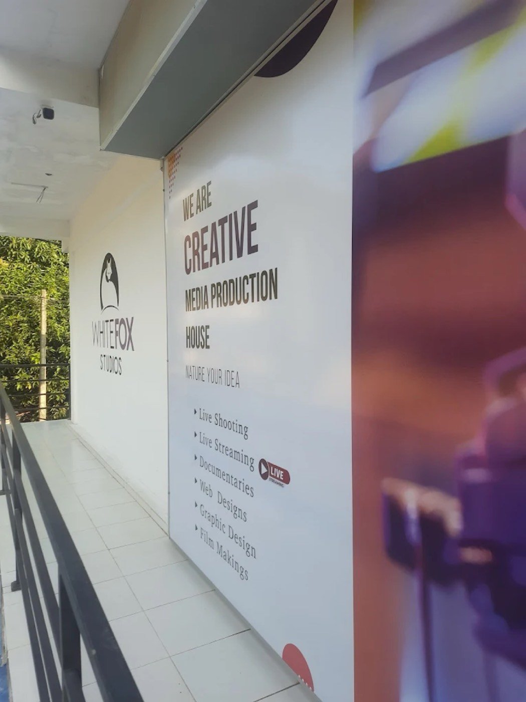 Studio wall graphic: We are a creative media production house — live shooting, live streaming, documentaries, web design, graphic design, film making